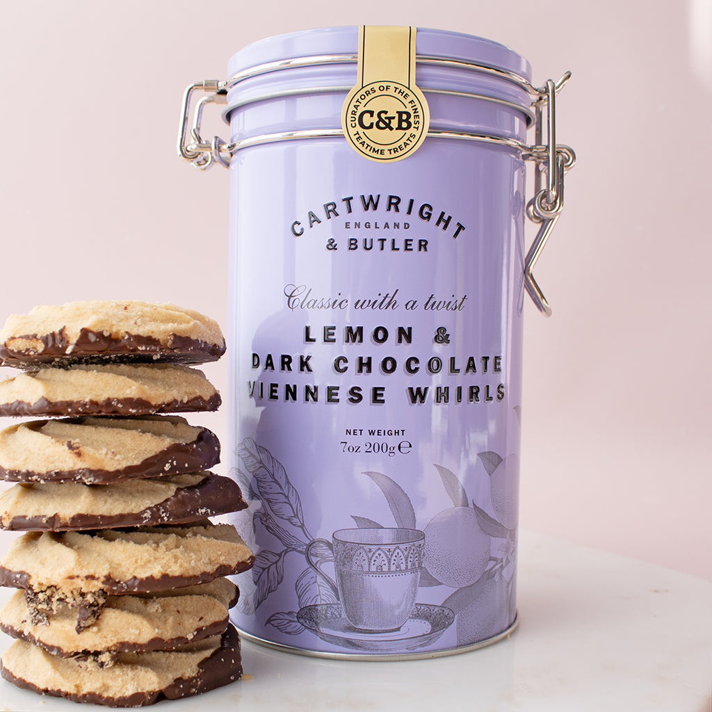 Cartwright & Butler lemon and dark chocolate viennese whirls tin with cookies on a light pink background