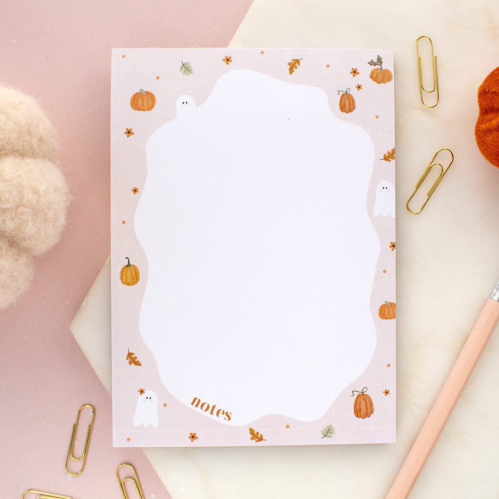 Notebook with ghost and pumpkin design on a pink background
